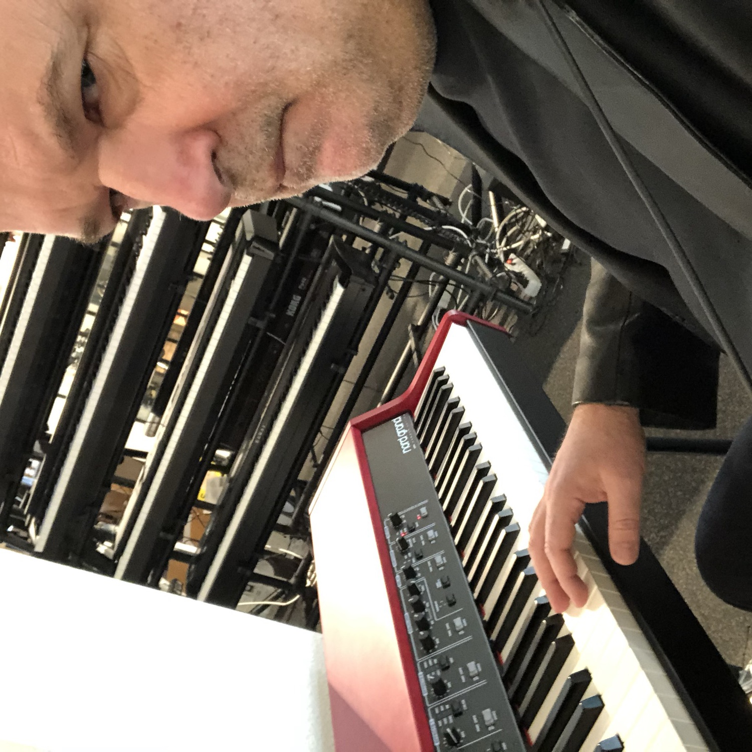 Michael Gassmann at a red Nord keyboard, backstage